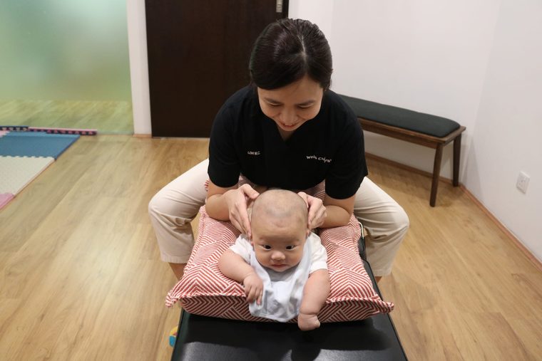 A chiropractor checking a baby lying on the treatment table