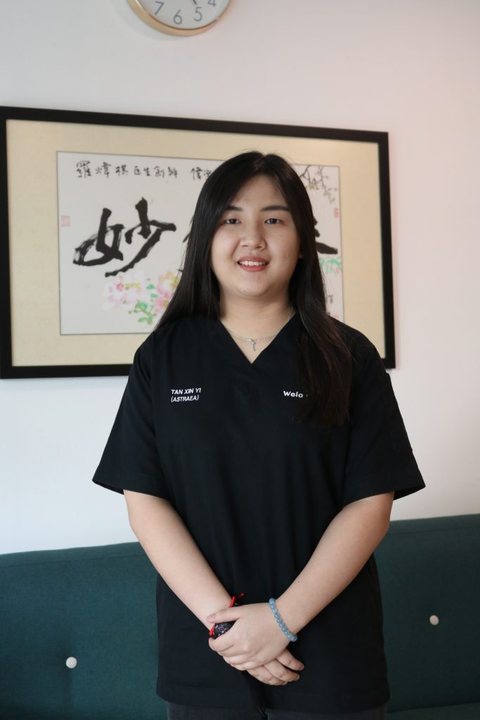 Portrait of Xin Yi in black scrubs